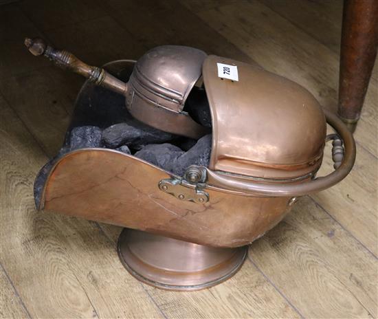 A copper helmet shaped coal scuttle, with swing handle, and shovel
